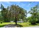 Well-maintained front yard of a single-story home, featuring mature trees and a detached storage shed at 1879 Richmond St, Charleston, SC 29407
