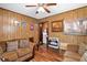 Cozy living room featuring wood paneling, plush seating, and a ceiling fan at 1879 Richmond St, Charleston, SC 29407