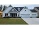 Charming new construction with white siding, gray accents, manicured lawn, and a two-car garage at 229 Huguenot Trl, Huger, SC 29450