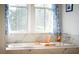 Bright bathroom showcasing a soaking tub under a window with light-filtering curtains at 2312 Rushland Landing Rd, Johns Island, SC 29455