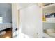 Bright bathroom features a white subway tiled shower-tub with a gold shower curtain and white shelving at 2312 Rushland Landing Rd, Johns Island, SC 29455