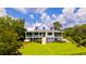 Stunning two-story home featuring a metal roof, wraparound porch, and well-manicured lawn at 2312 Rushland Landing Rd, Johns Island, SC 29455