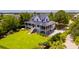 Beautiful two-story home with lush green lawn, screened in porches, and large wooden staircase at 2312 Rushland Landing Rd, Johns Island, SC 29455