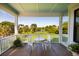 Outdoor porch with a table and chairs overlooking a serene pond at 2312 Rushland Landing Rd, Johns Island, SC 29455