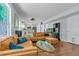 Open-concept living room with seating, modern kitchen view, and wood flooring at 2773 Forest Dew Ct, Charleston, SC 29414