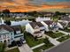 A serene community view with lush landscaping surrounding homes by a tranquil lake reflects the sunset, creating a captivating vista at 292 Calm Water Way, Summerville, SC 29486