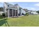 Well-manicured backyard with patio, screen porch, and lush green lawn at 292 Calm Water Way, Summerville, SC 29486