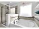 Inviting bathroom features glass-enclosed shower, soaking tub, & decorative chandelier at 292 Calm Water Way, Summerville, SC 29486