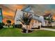 Inviting two-story home featuring a covered front porch, beautiful landscaping, and a well-maintained lawn under a colorful sky at 292 Calm Water Way, Summerville, SC 29486