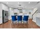 Modern kitchen with stainless steel appliances, granite countertops, white cabinets, bar seating, and hardwood floors at 292 Calm Water Way, Summerville, SC 29486