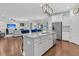 Kitchen featuring island with sink, granite countertops, white cabinets, stainless steel appliances, open to the living room at 292 Calm Water Way, Summerville, SC 29486