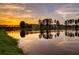 Scenic lake reflecting a colorful sky, framed by lush trees, enhancing the peaceful community ambiance at 292 Calm Water Way, Summerville, SC 29486