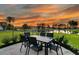 Outdoor patio featuring a dining table with seating, overlooking a serene lake at sunset at 292 Calm Water Way, Summerville, SC 29486