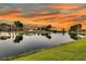 Scenic view of the community pond with lush green grass and a colorful sky reflecting on the water at 292 Calm Water Way, Summerville, SC 29486