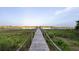 Picturesque long wooden dock leads to waterfront, offering serene views and peaceful escape into nature at 3121 Marshgate Dr, Seabrook Island, SC 29455