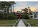 Exterior view from the dock of this waterfront home surrounded by lush trees and landscaping at 3121 Marshgate Dr, Seabrook Island, SC 29455