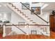 Elegant staircase with white railings and wood treads, adorned with artwork for a sophisticated touch at 3121 Marshgate Dr, Seabrook Island, SC 29455