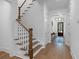 Hallway featuring a staircase with wooden railings, wood flooring, and access to the front door at 3226 Waverly Ln, Johns Island, SC 29455