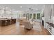 Bright and airy living room featuring hardwood floors, a cozy fireplace, and seamless connection to kitchen and dining areas at 3226 Waverly Ln, Johns Island, SC 29455