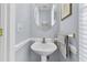 Powder room featuring a pedestal sink, oval mirror, and light blue walls at 3257 Heathland Way, Mount Pleasant, SC 29466