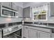 Updated kitchen features stainless steel appliances, granite countertops, and gray cabinetry at 3257 Heathland Way, Mount Pleasant, SC 29466