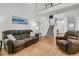 Comfortable living room featuring hardwood floors, leather seating, staircase, and abundant natural light at 3257 Heathland Way, Mount Pleasant, SC 29466