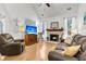 Warm living room featuring hardwood floors, fireplace, comfortable leather seating, and abundant natural light at 3257 Heathland Way, Mount Pleasant, SC 29466