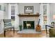 Cozy living room features a fireplace with guitar and mantel, hardwood floors, and two windows at 3257 Heathland Way, Mount Pleasant, SC 29466