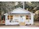 Charming white cottage with a welcoming front porch and lush green surroundings at 3480 Johan Blvd, Johns Island, SC 29455