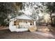 Charming white cottage with a welcoming front porch and lush green surroundings at 3480 Johan Blvd, Johns Island, SC 29455
