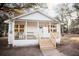 Charming white cottage with a welcoming front porch and lush green surroundings at 3480 Johan Blvd, Johns Island, SC 29455
