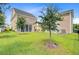 Picturesque backyard featuring a screened porch, lush green lawn, and mature trees providing privacy at 357 Parish Farms Dr, Summerville, SC 29486