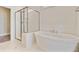 A relaxing bathroom featuring a modern tub and glass-door shower with marble-like tiling at 357 Parish Farms Dr, Summerville, SC 29486