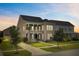 Elegant two-story home with a classic porch, professional landscaping, and warm exterior lighting at dusk at 357 Parish Farms Dr, Summerville, SC 29486