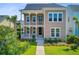 Charming tan two-story home featuring a double porch, manicured lawn, and lush landscaping at 357 Parish Farms Dr, Summerville, SC 29486