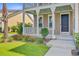 Close-up of the front porch with a charming tan exterior and well-kept landscaping at 357 Parish Farms Dr, Summerville, SC 29486