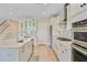 Modern kitchen with stainless steel appliances, granite countertops, a central island, and elegant glass-front cabinets at 357 Parish Farms Dr, Summerville, SC 29486
