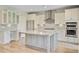 Open kitchen boasts an island, granite countertops, stainless appliances, and white cabinets for modern living at 357 Parish Farms Dr, Summerville, SC 29486