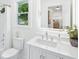 Bathroom vanity with decorative mirror, chrome faucet, toilet, and shower with trailing floral accent at 43 Heathwood Dr, Charleston, SC 29407