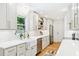 Well-lit kitchen with white cabinets, quartz counters, stainless appliances, and a view to the backyard at 43 Heathwood Dr, Charleston, SC 29407