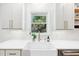 A bright kitchen featuring a farmhouse sink, quartz countertops, and views of the backyard at 43 Heathwood Dr, Charleston, SC 29407