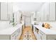 Modern white kitchen with stainless steel appliances, quartz countertops, and a decorative runner at 43 Heathwood Dr, Charleston, SC 29407