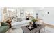 Bright living room featuring a white sofa, wood floors, stylish decor, and an open view to the kitchen at 43 Heathwood Dr, Charleston, SC 29407