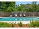 An in-ground pool is surrounded by lounge chairs, greenery, and a privacy fence for a secluded feel at 43 Heathwood Dr, Charleston, SC 29407