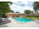 A private in-ground backyard pool next to a brick home. Four lounge chairs sit poolside at 43 Heathwood Dr, Charleston, SC 29407