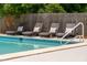 Four lounge chairs with patterned pillows sit poolside in a relaxing and private backyard at 43 Heathwood Dr, Charleston, SC 29407