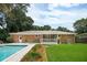 Brick home exterior with backyard pool, grassy lawn and covered porch at 43 Heathwood Dr, Charleston, SC 29407