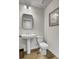 Elegant powder room features a pedestal sink, modern mirror, and decorative artwork at 501 Caledon Ct, Johns Island, SC 29455