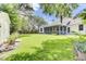 Expansive backyard featuring a screened porch, mature trees, and a well-maintained lawn, perfect for outdoor entertaining and relaxation at 5406 Dwight Dr, North Charleston, SC 29420