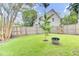 Fenced backyard with lush green grass and young trees, offering a private outdoor space with potential for gardening at 5406 Dwight Dr, North Charleston, SC 29420